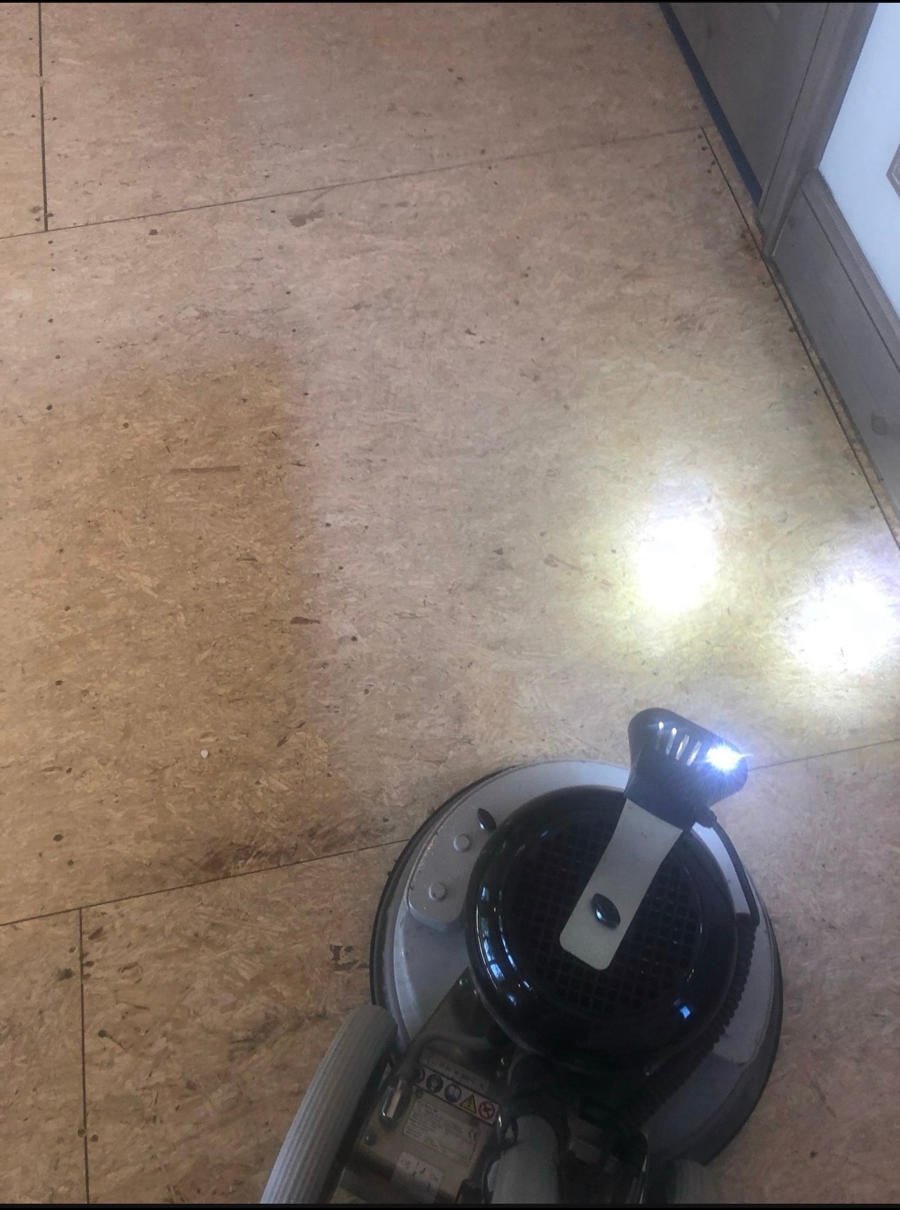 Sanding the subfloor with a floor sander to prepare for hardwood installation