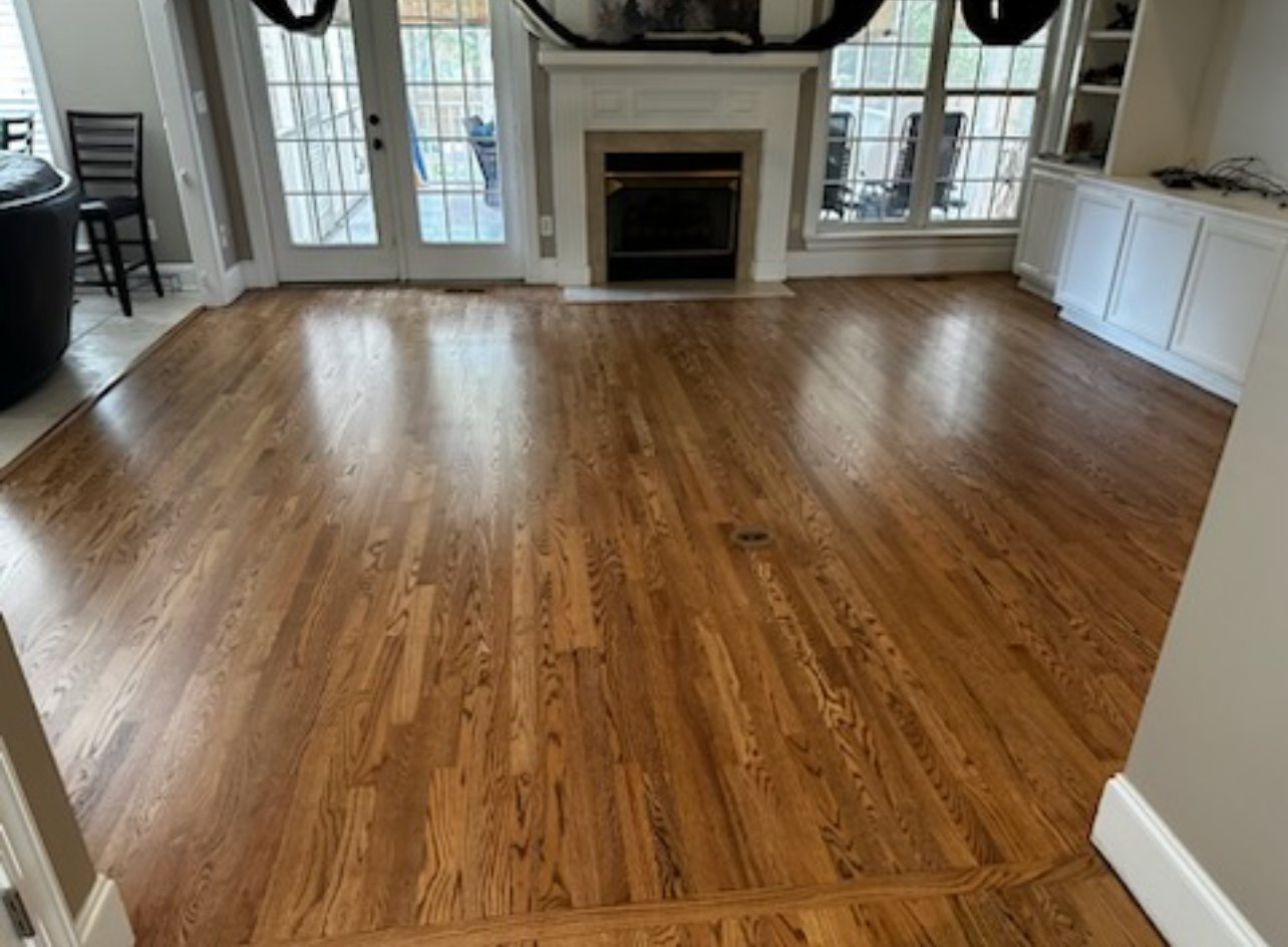 Refinished red oak hardwood floors in living room with fireplace