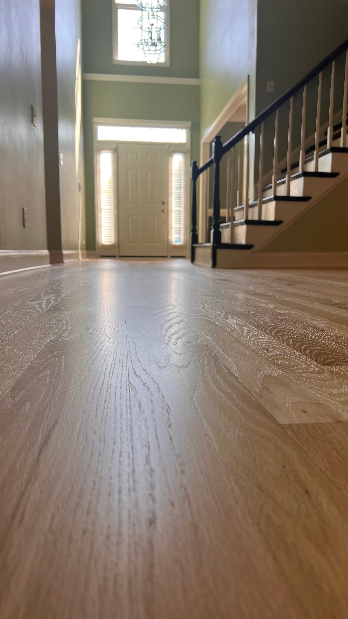 Low-angle view of freshly refinished white oak hardwood floor entryway